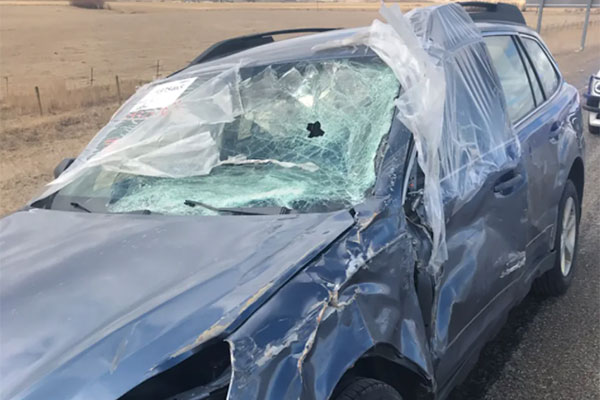 Man drives car with smashed up windshield wearing safety glasses